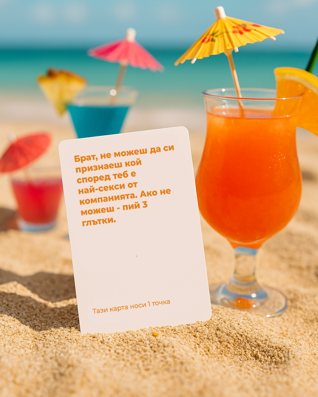 „Карта от играта Брат, не можеш – Beach Edition, забита в пясъка до цветни коктейли с чадърчета на плажен фон“